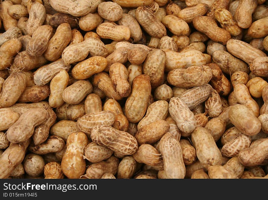 Pile of unshelled peanuts at a produce market.