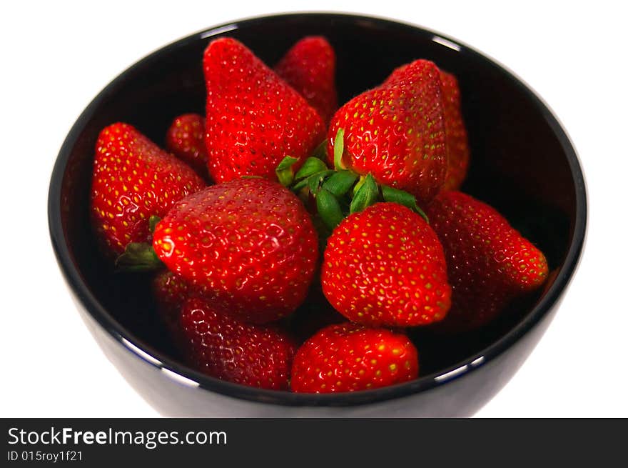 A black bown fully of bright red strawberries