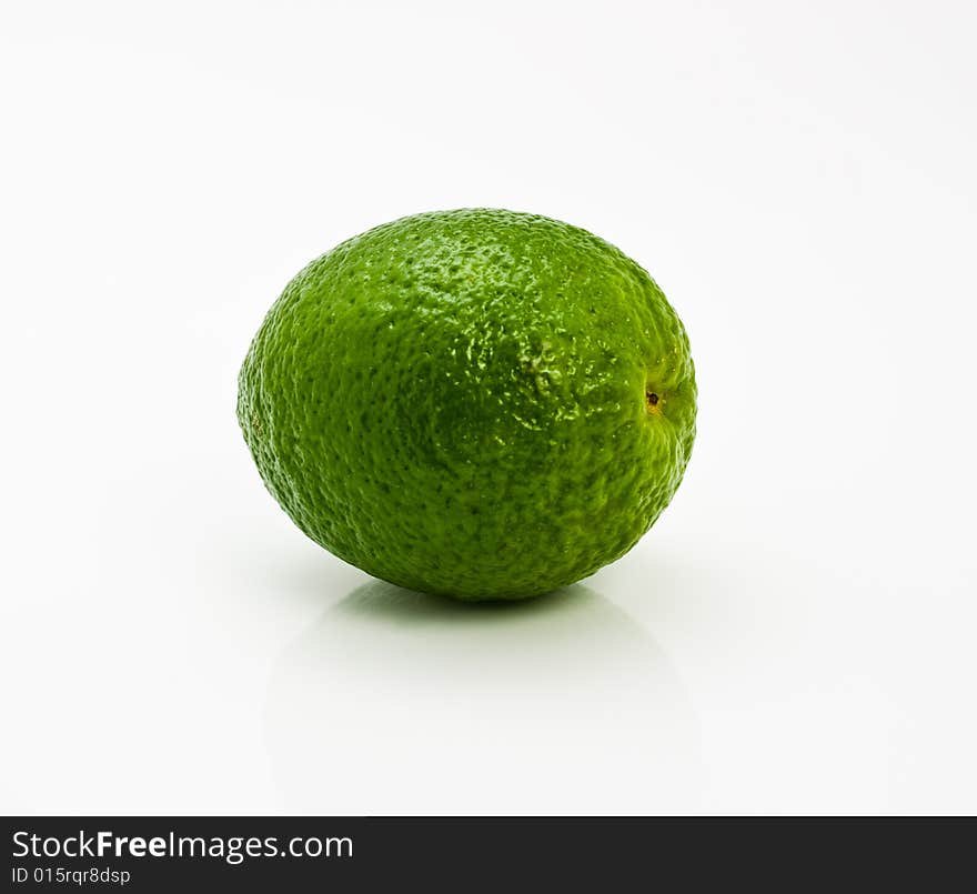 A fresh green lime on a white background. A fresh green lime on a white background