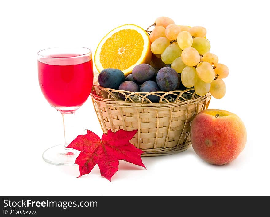 Red wine in wine-glass and ripe beautiful fruit peach plums grapes orange in basket on white background