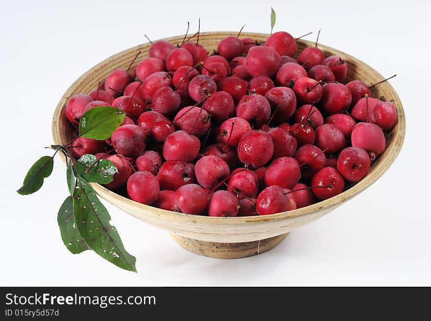 Small paradise apples in basket isolated on white background