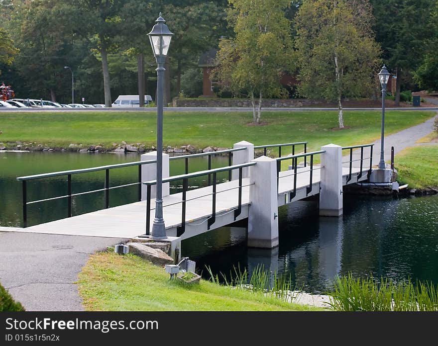 Foot bridge over the pond  in  Beverly, Massachusetts. Early fall when the trees are beginning to change colors.