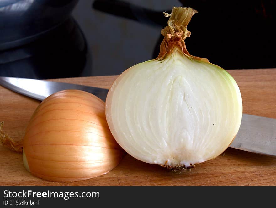 Half of bulb on a chopping board with a knife