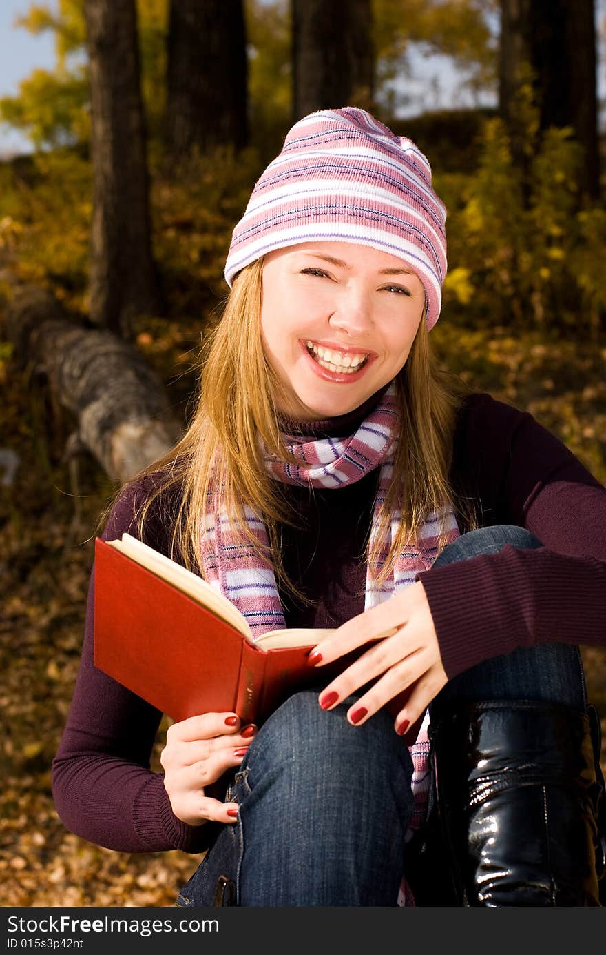 Girl Reading A Book In The Park