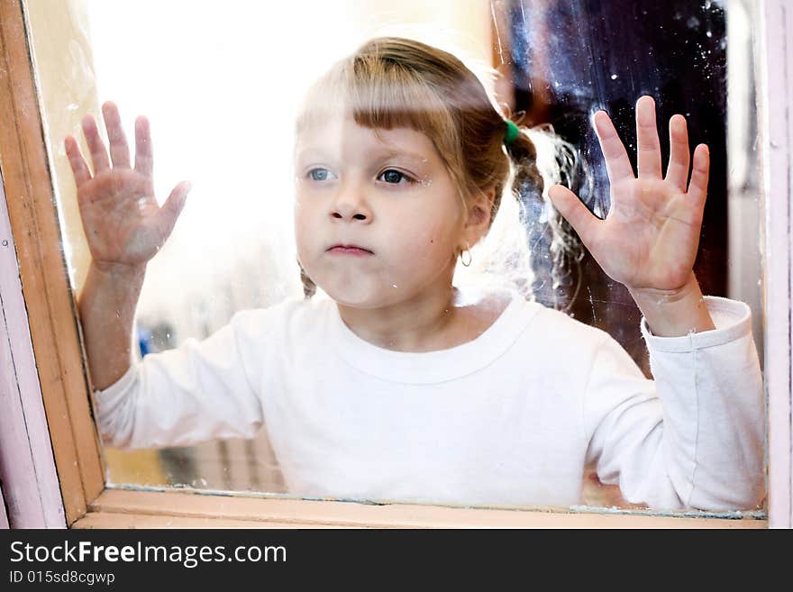 Portrait of a young girl  stands outside the window. Portrait of a young girl  stands outside the window.