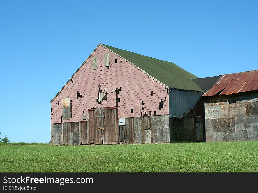 Old barn with grass and blue sky