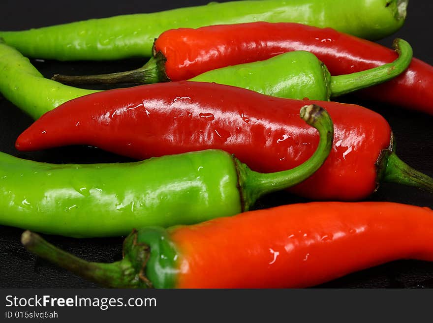 Red and green peppers on a dark background