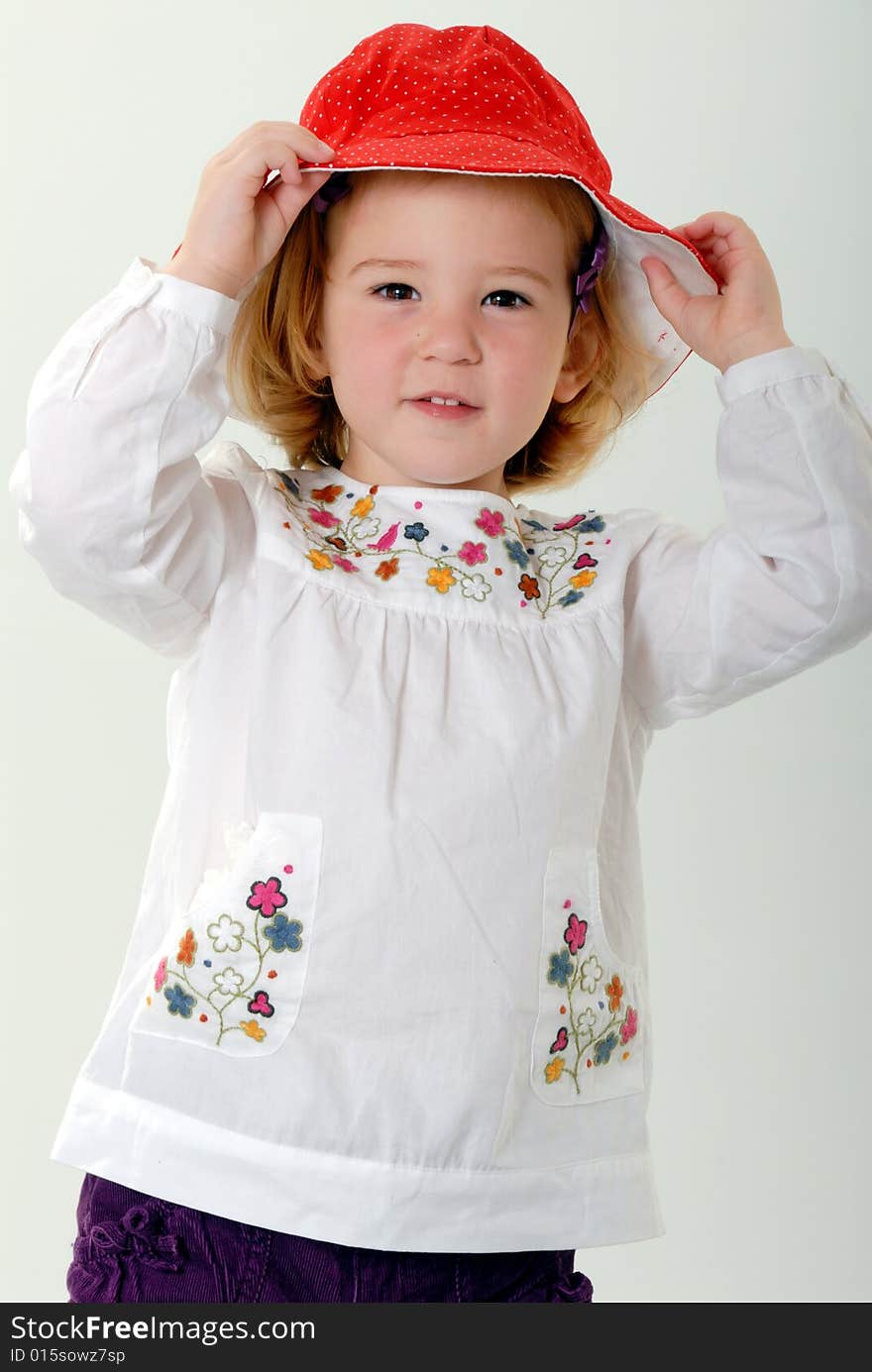 Blond Toddler Plays With Red Hat