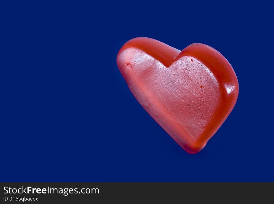 Red candy heart isolated on blue background