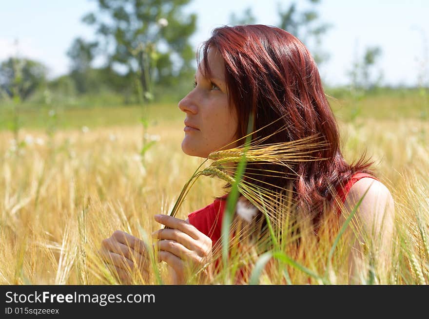 Girl resting in meadow with rye ears