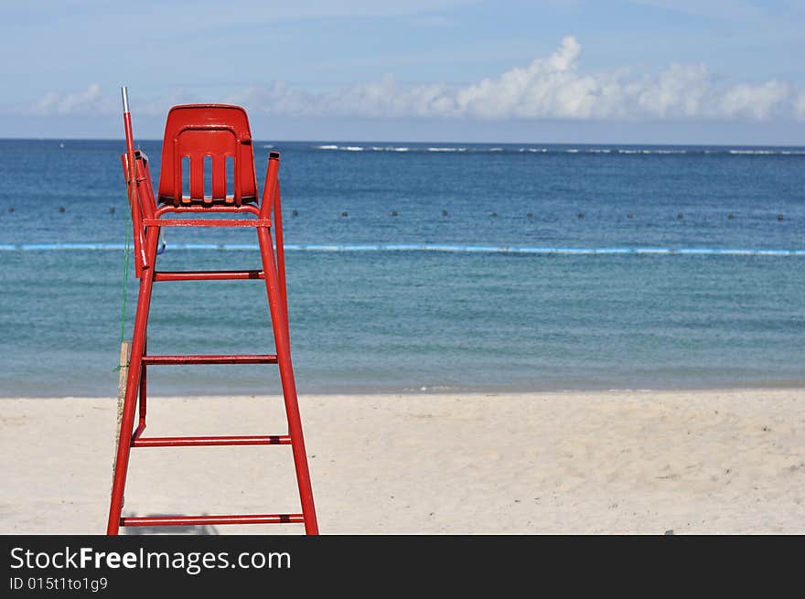 Blue beach with red lifeguard post