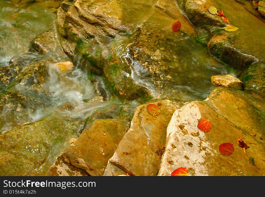 Small river running on stones acquired a moss. Small river running on stones acquired a moss