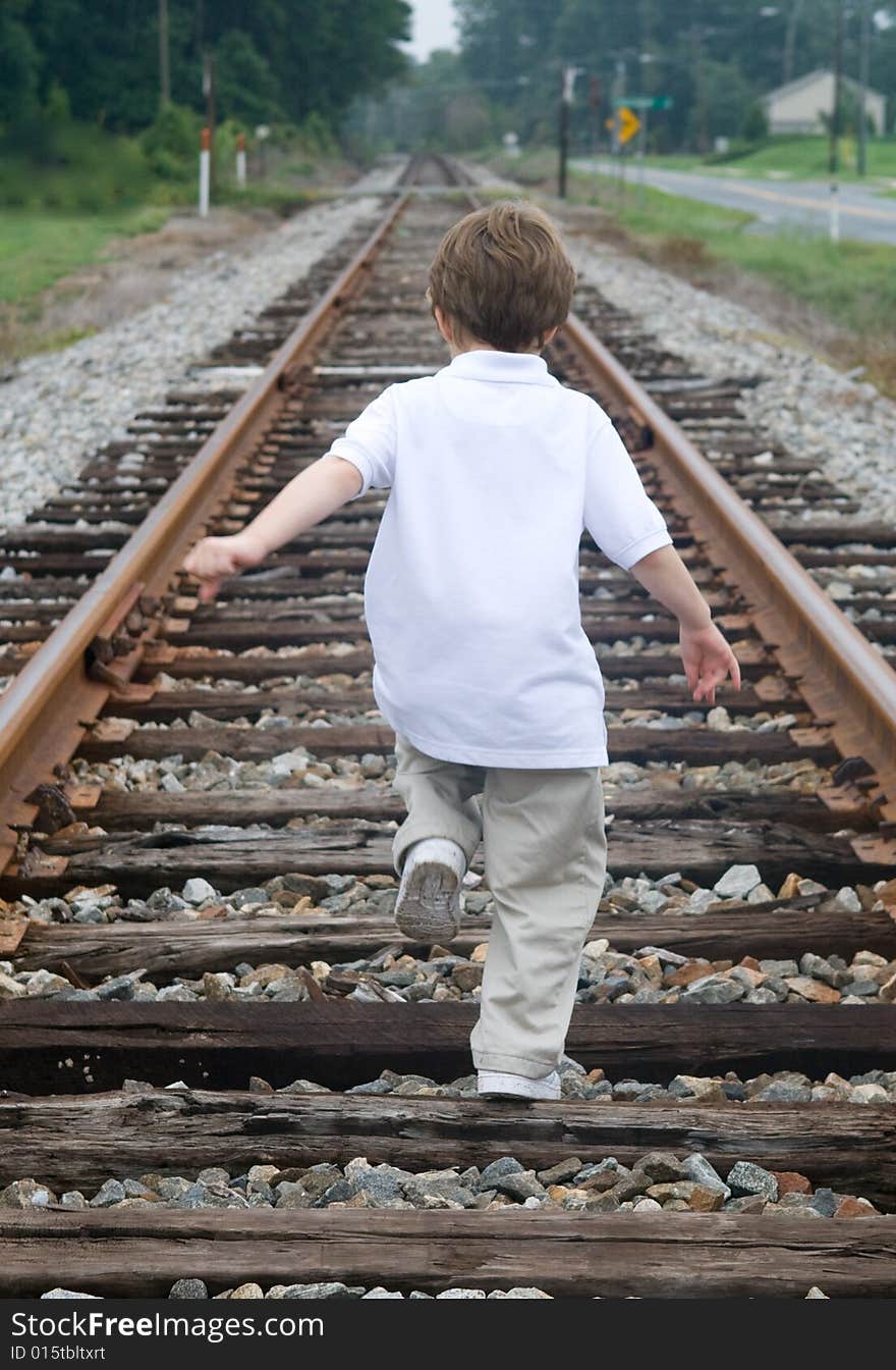 Child walking on the railroad tracks. Child walking on the railroad tracks