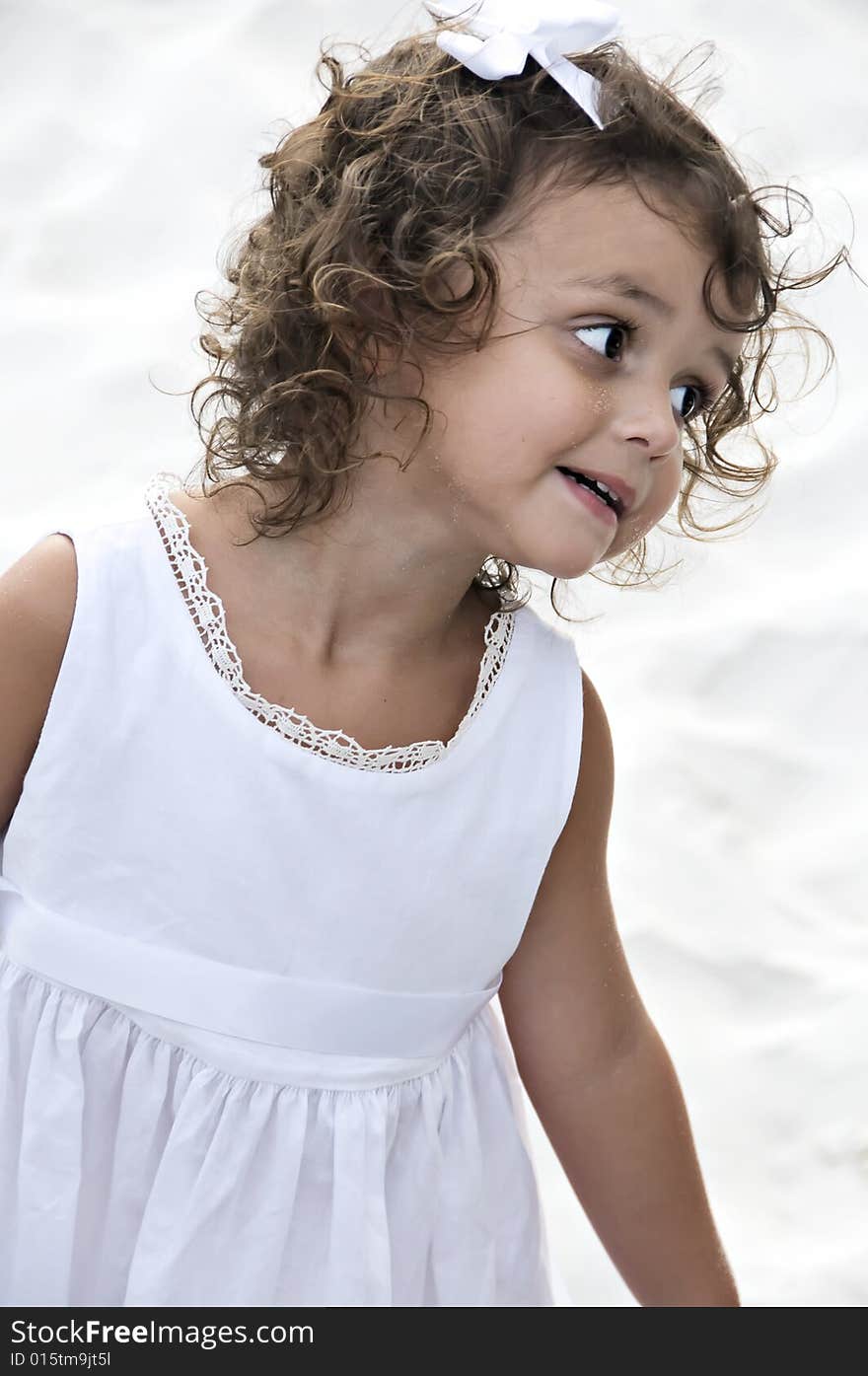 Cute little girl with curly hair making a silly face.