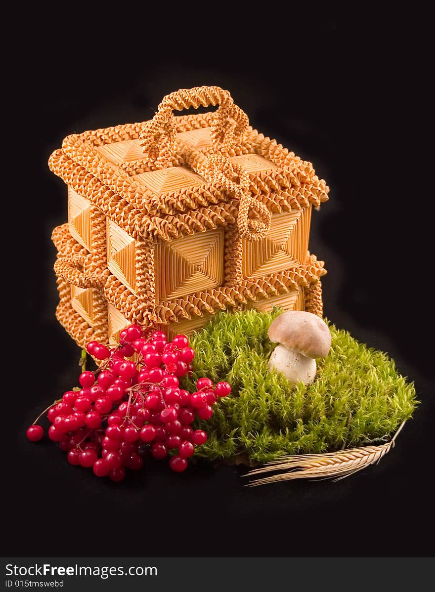 Casket from straw mushroom white and ear with berries guelder-rose red on black background