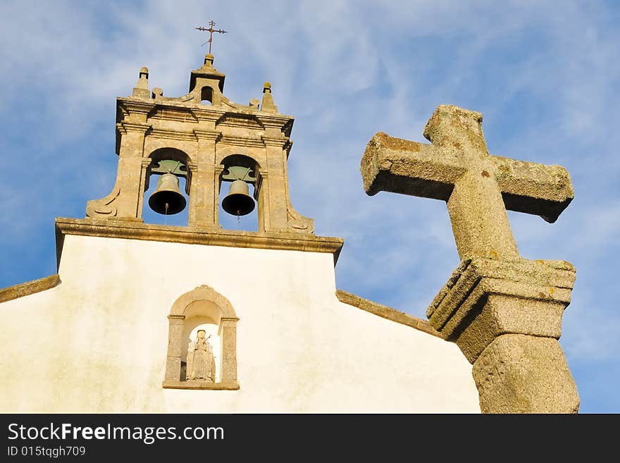 Church tower with bells and stone cross. Church tower with bells and stone cross