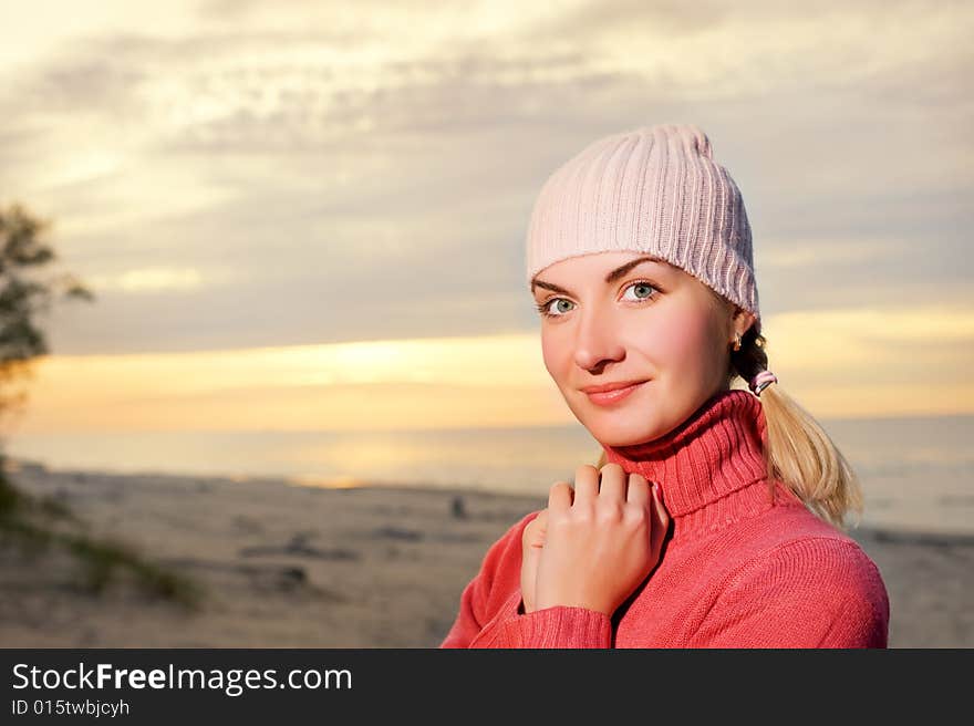 Young woman on a beach at sunset. Close-up portrait