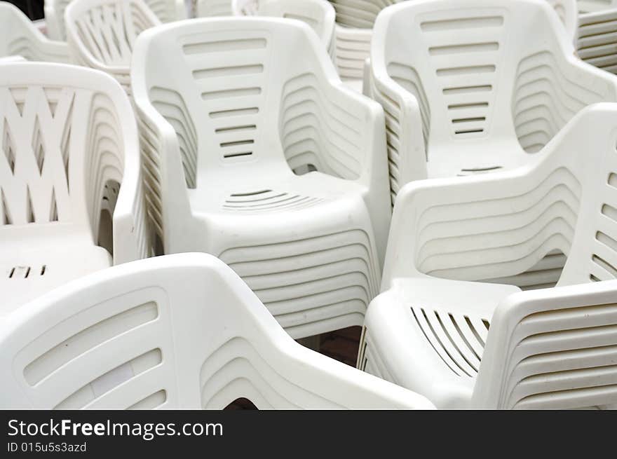 Stack of white plastic chairs on the street