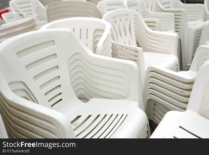 Stack of white plastic chairs on the street