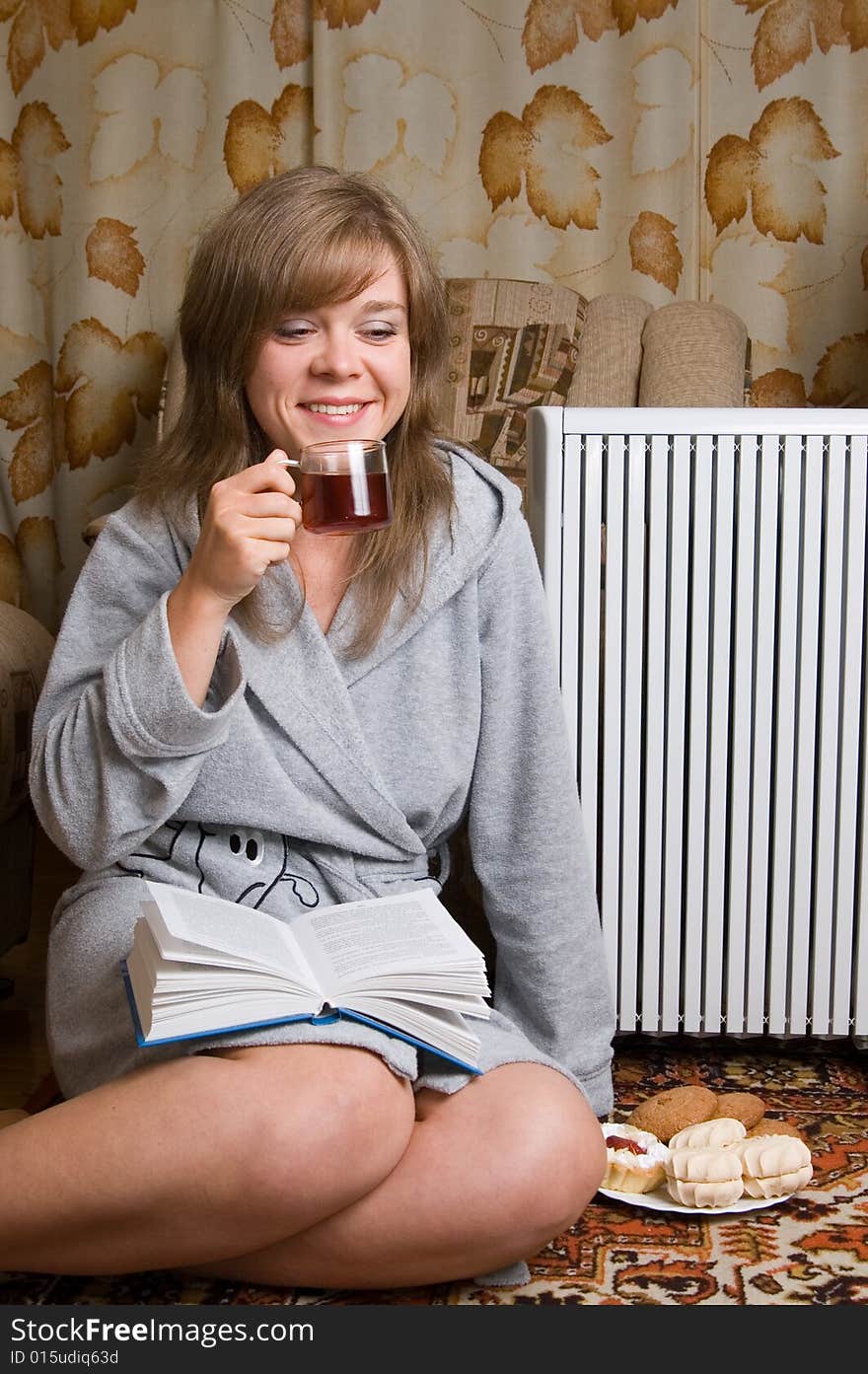 Young woman sits on a carpet in a living room