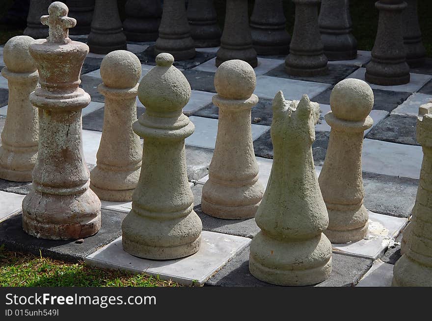 Set of chess pieces ready to be played, layed out on the lawn in the garden. Set of chess pieces ready to be played, layed out on the lawn in the garden