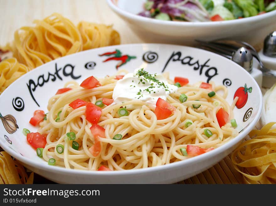 Some fresh spaghetti with tomatoes and spring onions. Some fresh spaghetti with tomatoes and spring onions