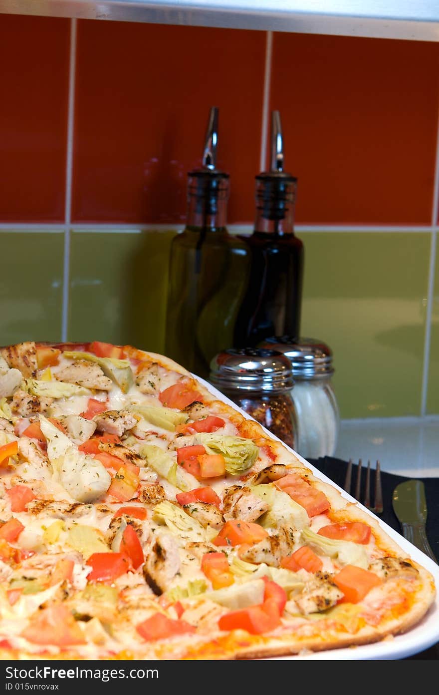 An image of Greek style pizza with artichokes and chicken