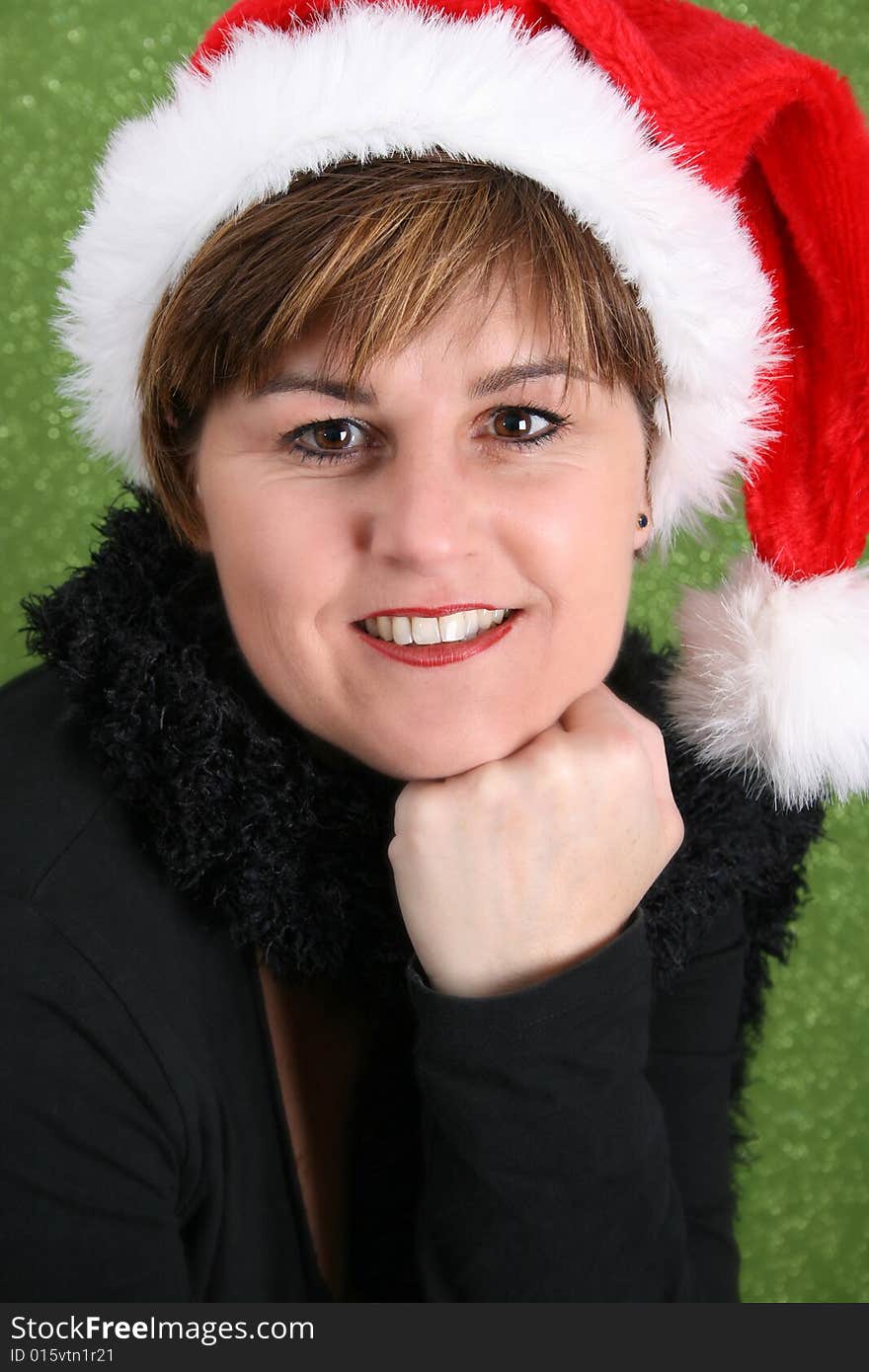 Adult female wearing a christmas hat, against a green background. Adult female wearing a christmas hat, against a green background