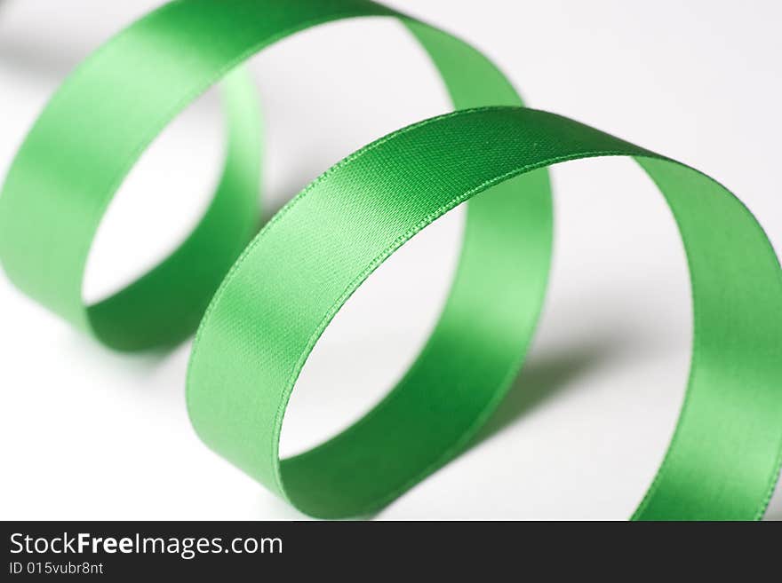 Green ribbon curling on white background. Green ribbon curling on white background