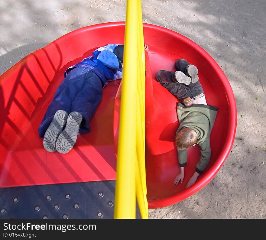 Boys go for a drive on the equipment of a playground