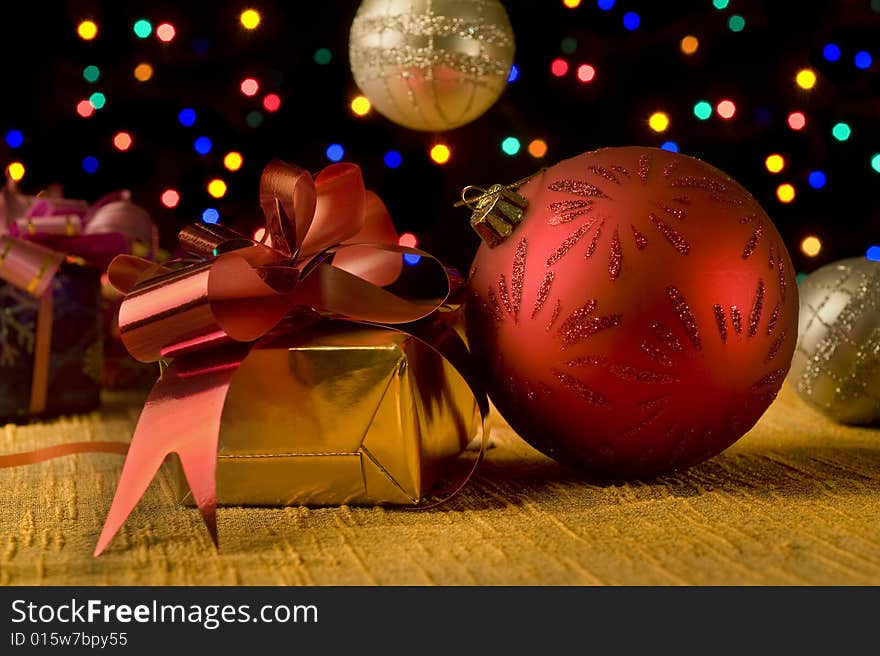 Christmas still life with presents, balls decoration and out of focus lights