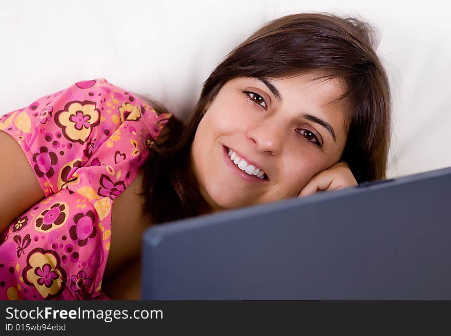 Beautifull young woman smiling and working on laptop from her house. Beautifull young woman smiling and working on laptop from her house