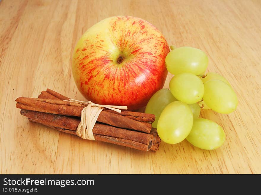 Apple grapes cinnamon on wood