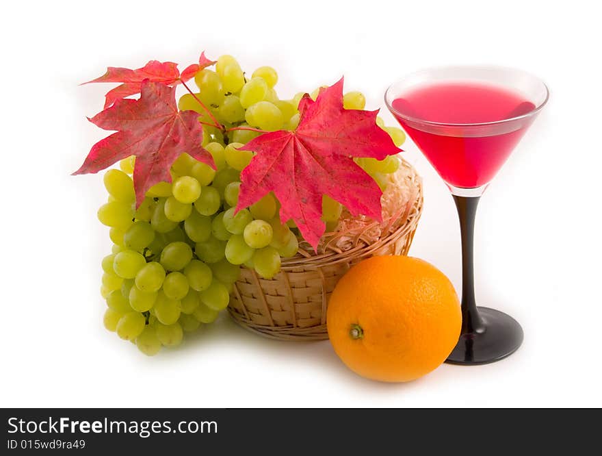 Autumn green sweet grapes and red maple leaves on white background