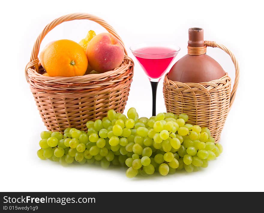 Green tasty grapes and bottles in yellow baskets on white background