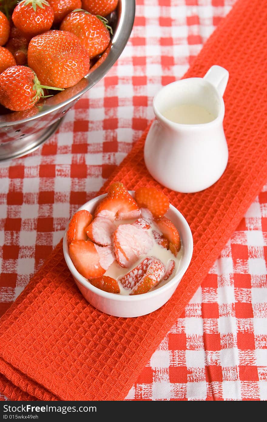 Sliced strawberries with cream in a white pot