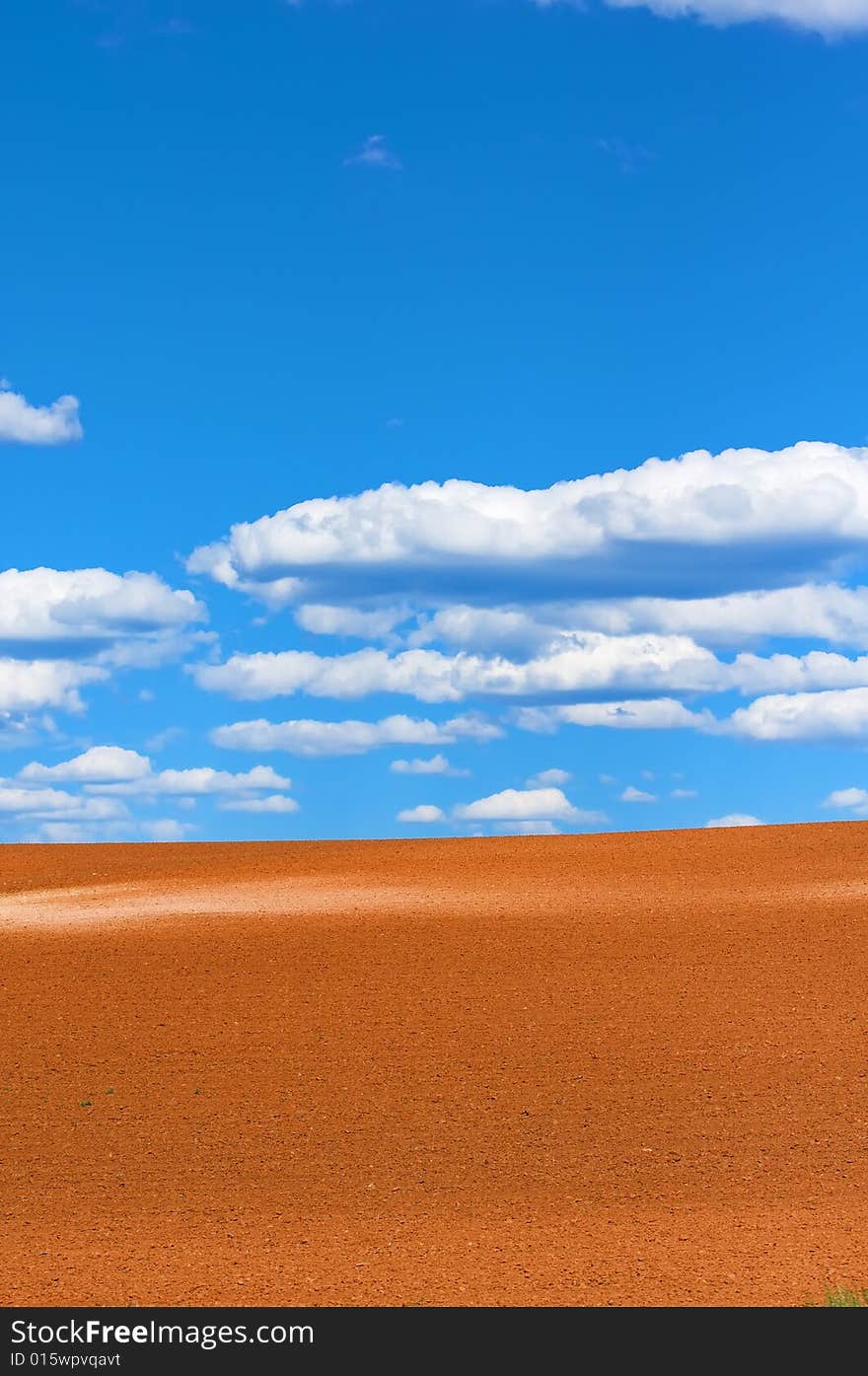 An image of bright blue sky beyond golden sand dunes. An image of bright blue sky beyond golden sand dunes