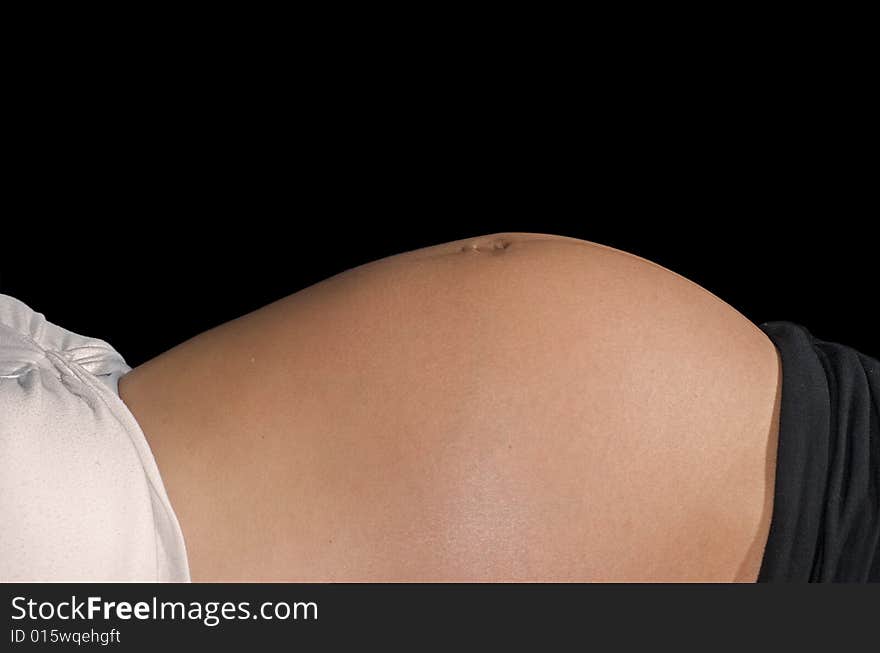 Young mother reclining in front of a black background. Young mother reclining in front of a black background