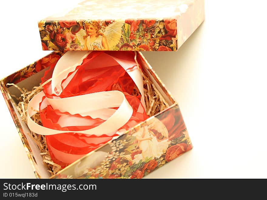 Against the backdrop of gift box with a beautiful figure and the red and white ribbon. Against the backdrop of gift box with a beautiful figure and the red and white ribbon