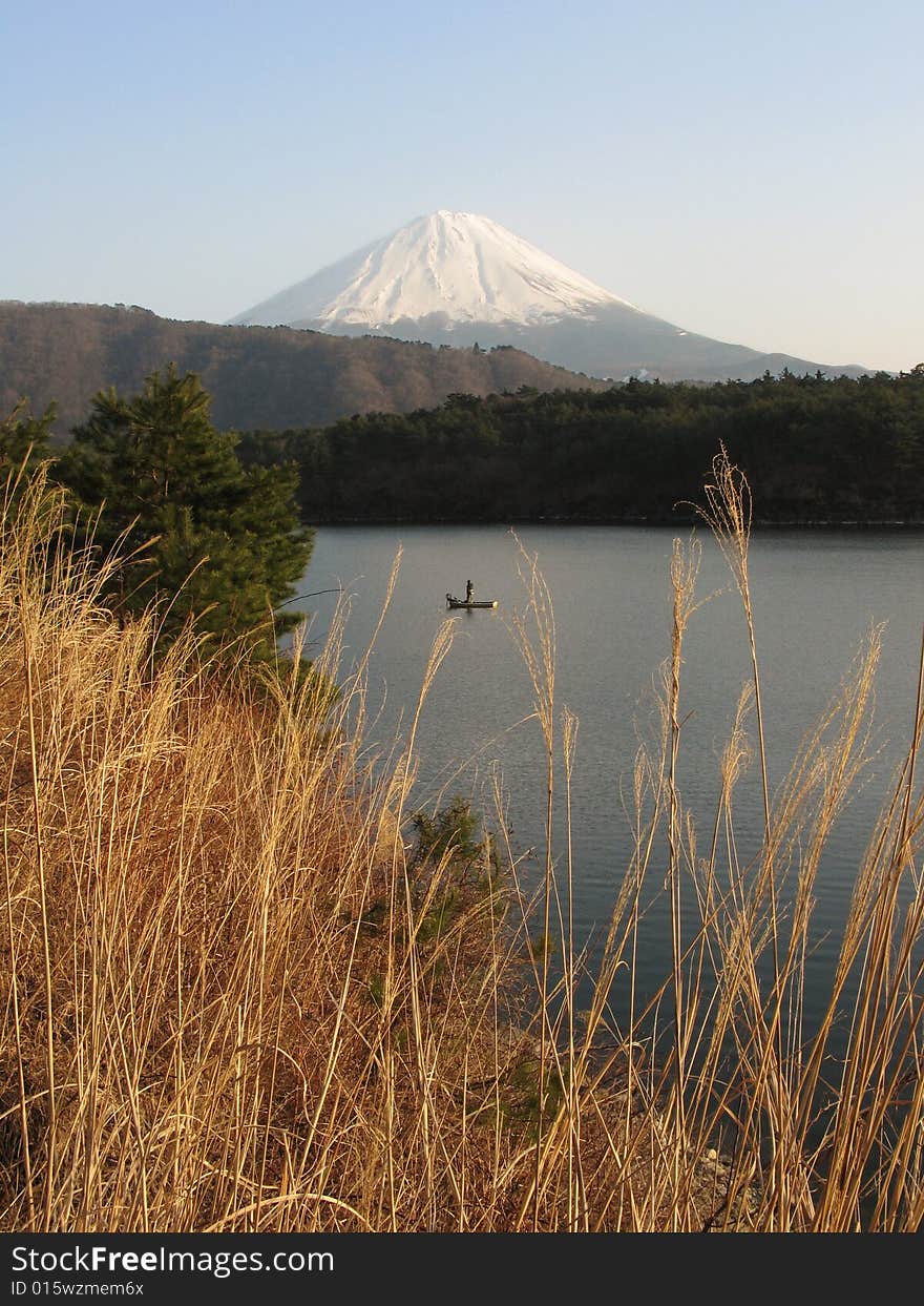 Fisherman in a lake by Mount Fuji. Fisherman in a lake by Mount Fuji