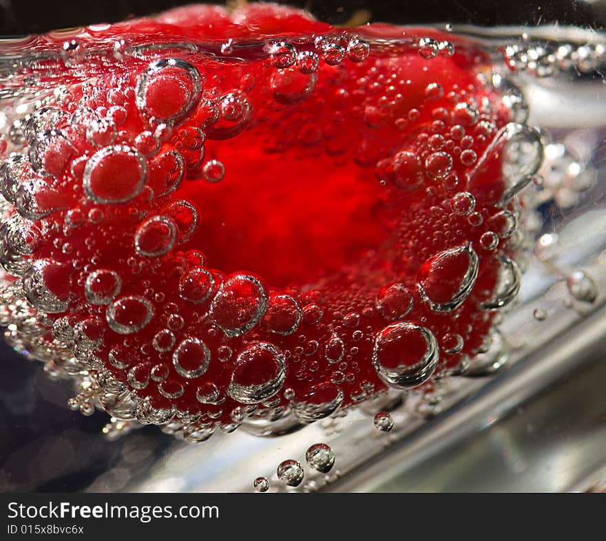 A raspberry floating in a glass of tonic water. A raspberry floating in a glass of tonic water.