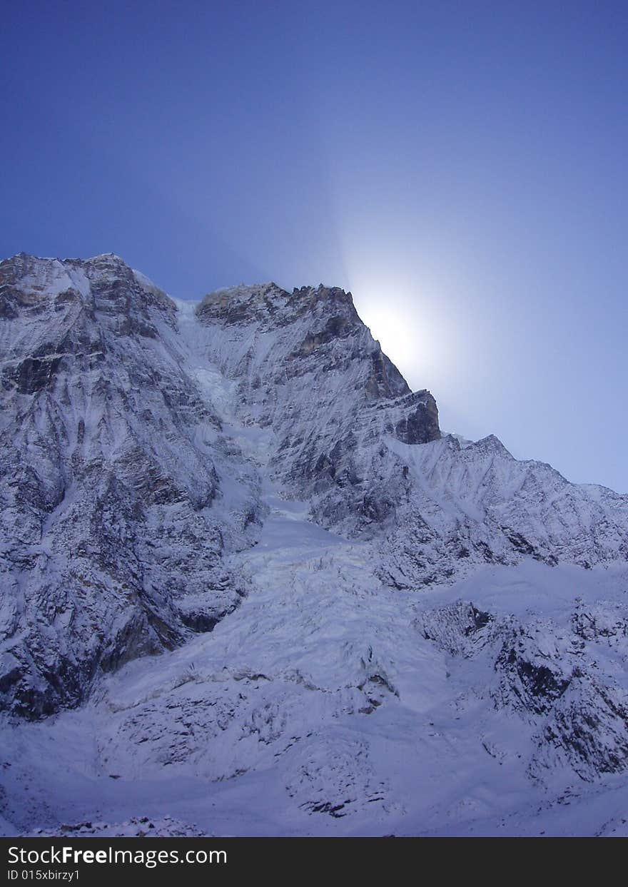 Rays of sunlight streaming behind the peak of the mountain. Along the sikkim, mount kanchenjunga trek. Rays of sunlight streaming behind the peak of the mountain. Along the sikkim, mount kanchenjunga trek