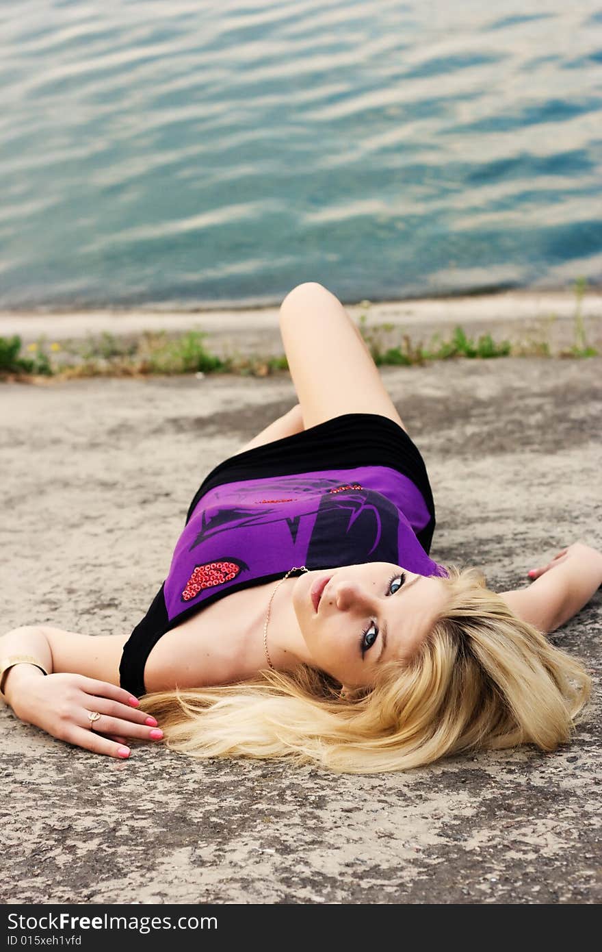 Portrait of beautiful woman lying on the dam