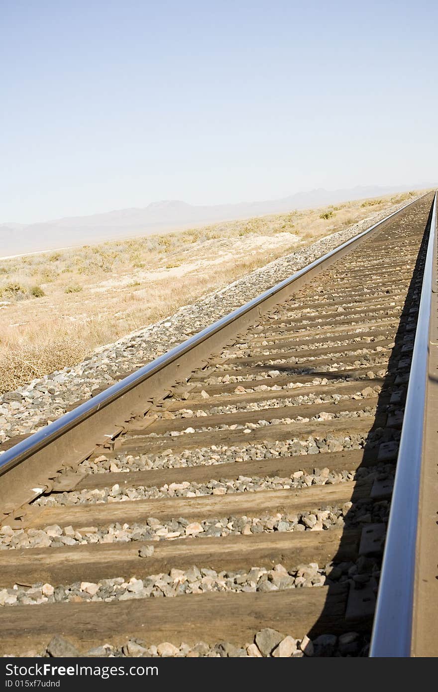 Railroad track in the Nevada desert with vanishing point and some blue sky for copy space. Railroad track in the Nevada desert with vanishing point and some blue sky for copy space.