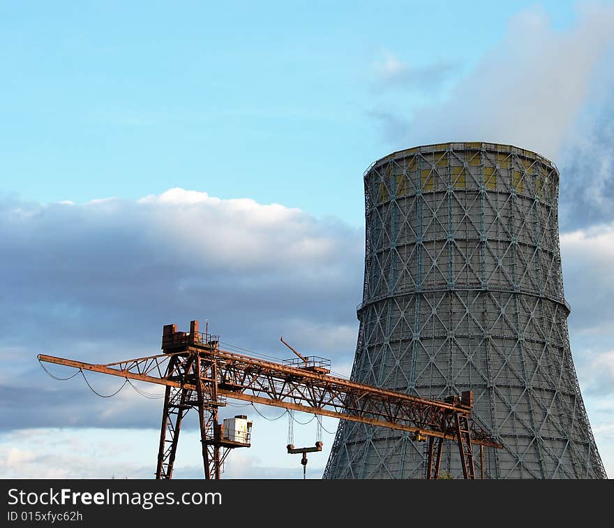 The bridge crane and cooling tower against the sky