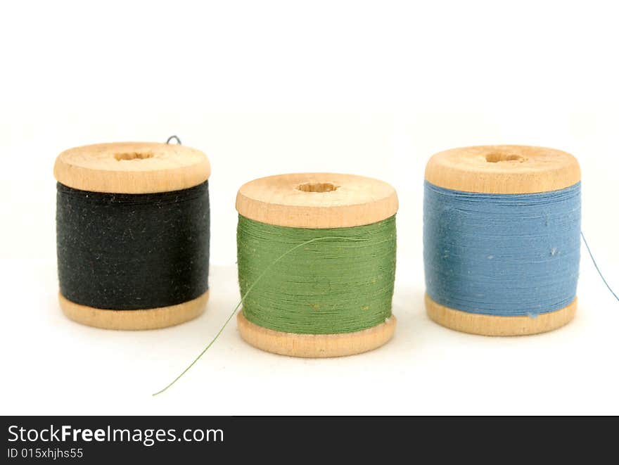 Isolated blue, green & black spools on white background. Isolated blue, green & black spools on white background