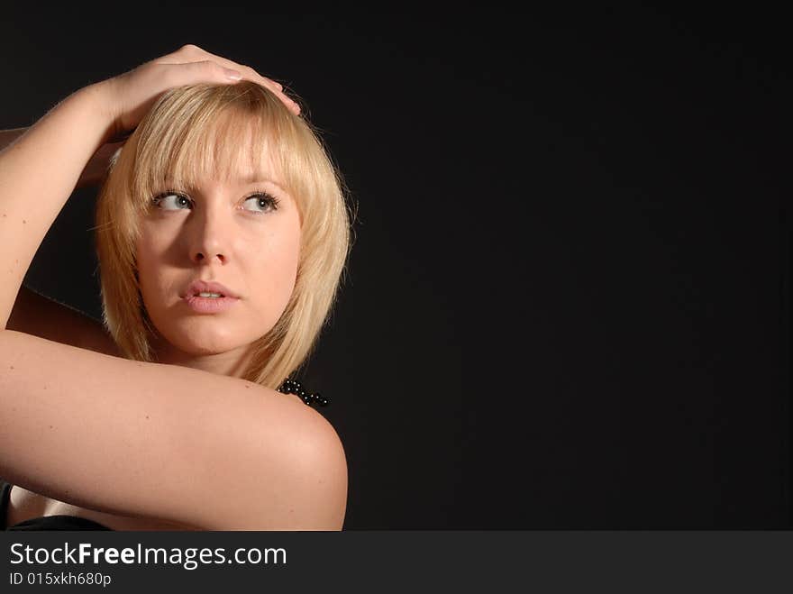 Sexy blond glamour girl posing against dark background