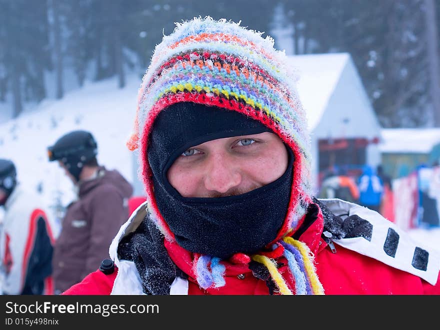 Masked skier man in funny hat Laughing on mountain resort in Europe