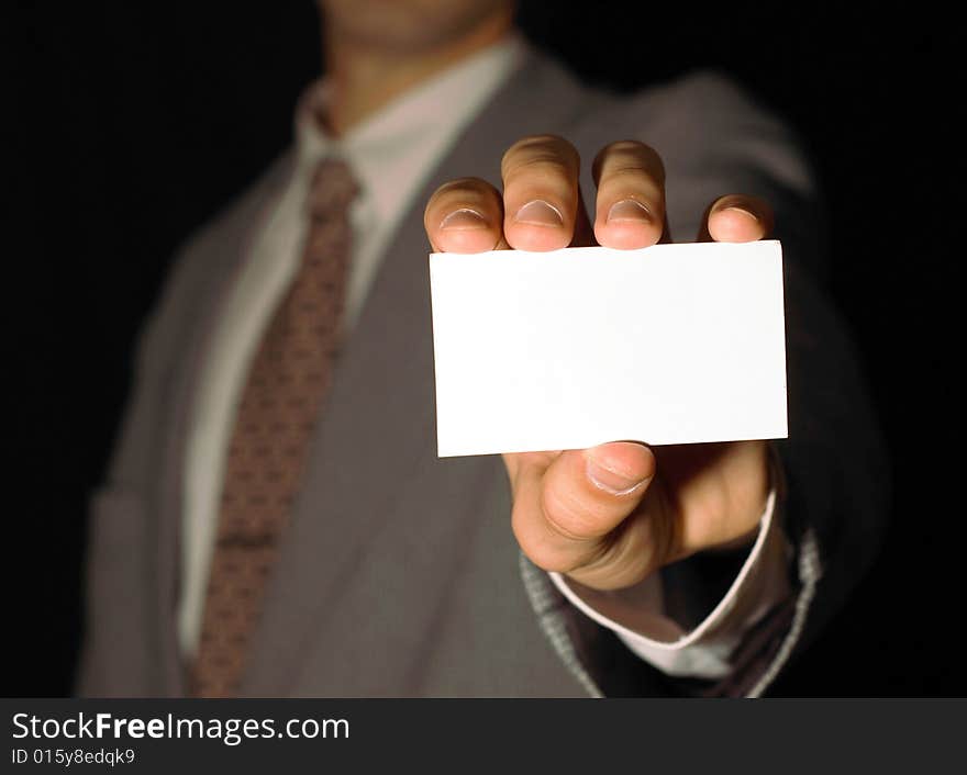 Business man holding visiting card on black