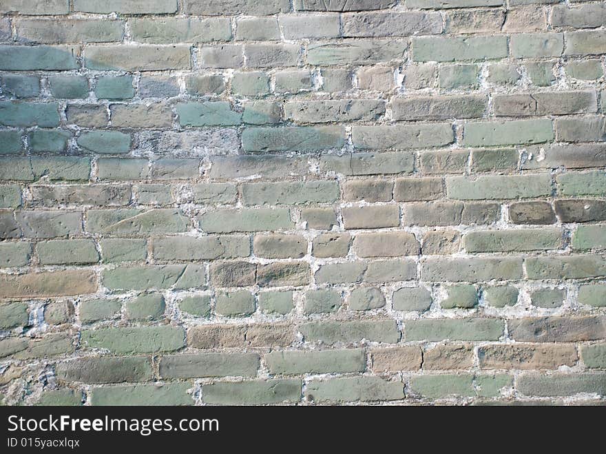 The  weathered colorful ancient brick wall of a Chinese old building. The  weathered colorful ancient brick wall of a Chinese old building.